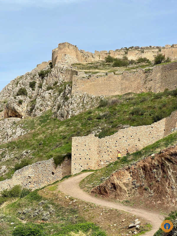 Akrocorinthos, the biggest ancient fortress of the Peloponnese. - Gastronomy Tours a stone wall on a hill in Akrocorinth.